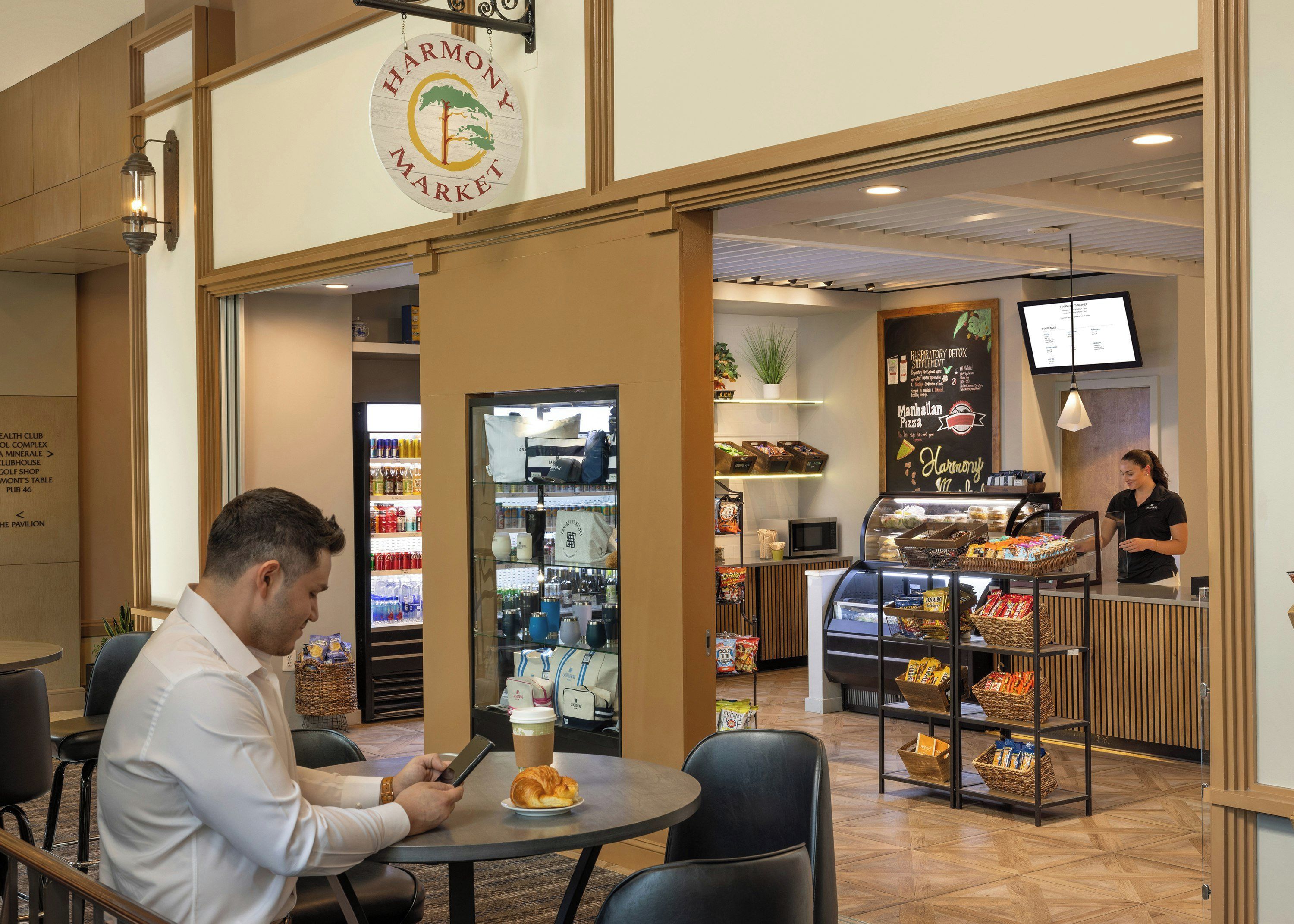 A Harmony Market cafe with a seating area, a counter with baked goods, and a refrigerated display.