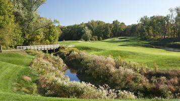 Stroll across the wooden bridge and enjoy the serene golf course with lush greenery and scenic water features.