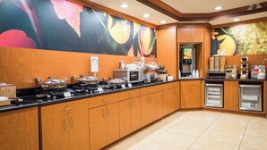 A modern kitchen with wooden cabinets, a black countertop, and a microwave. There are two refrigerators and a coffee station. - Fairfield Inn & Suites by Marriott Knoxville/East (Knoxville)