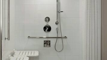 Une salle de bain moderne équipée d’une douche, de toilettes et d’un banc.