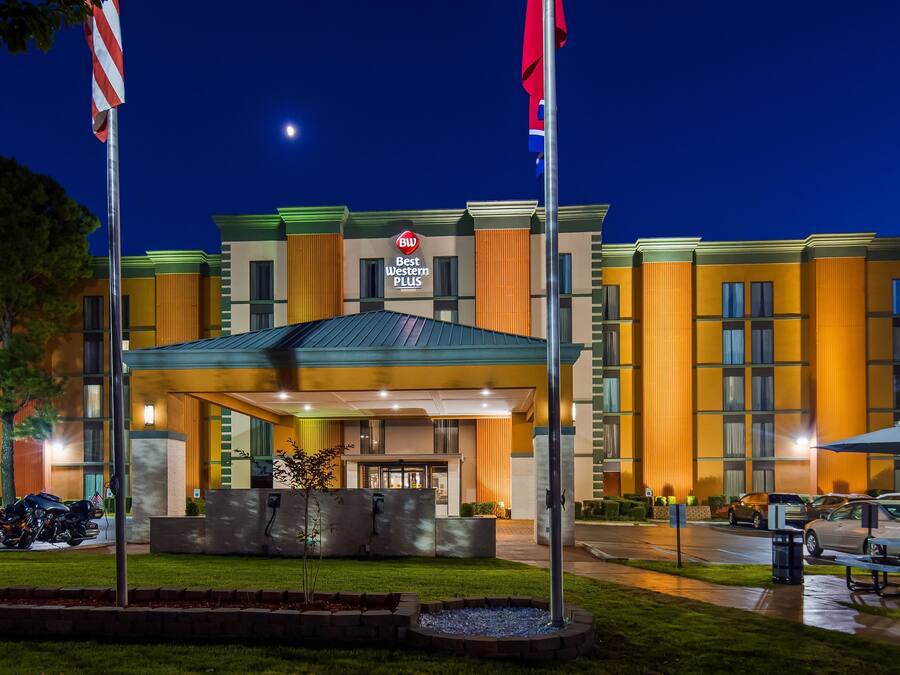 A hotel with a modern design, featuring a prominent entrance and a well-maintained lawn.