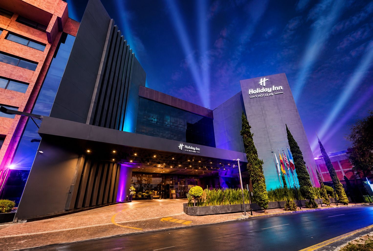 A Holiday Inn hotel with a modern facade, large windows, and a prominent entrance.