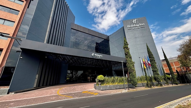 A modern Holiday Inn hotel with a prominent entrance, large glass facade, and flags. - Holiday Inn Mexico Dali Airport by IHG (Mexico City)