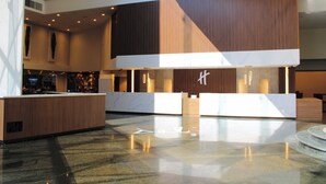 A modern hotel lobby with a reception desk, seating area, and a large window. - Holiday Inn Mexico Dali Airport by IHG (Mexico City)