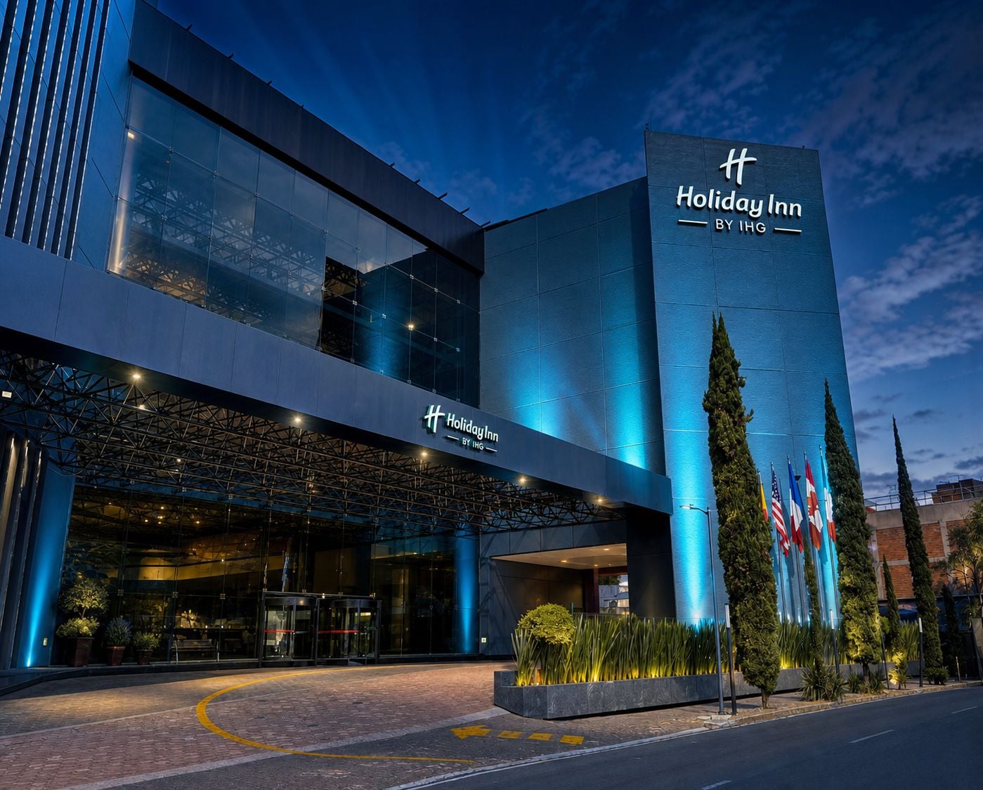 Un hotel Holiday Inn con fachada moderna, amplios ventanales y una entrada destacada.