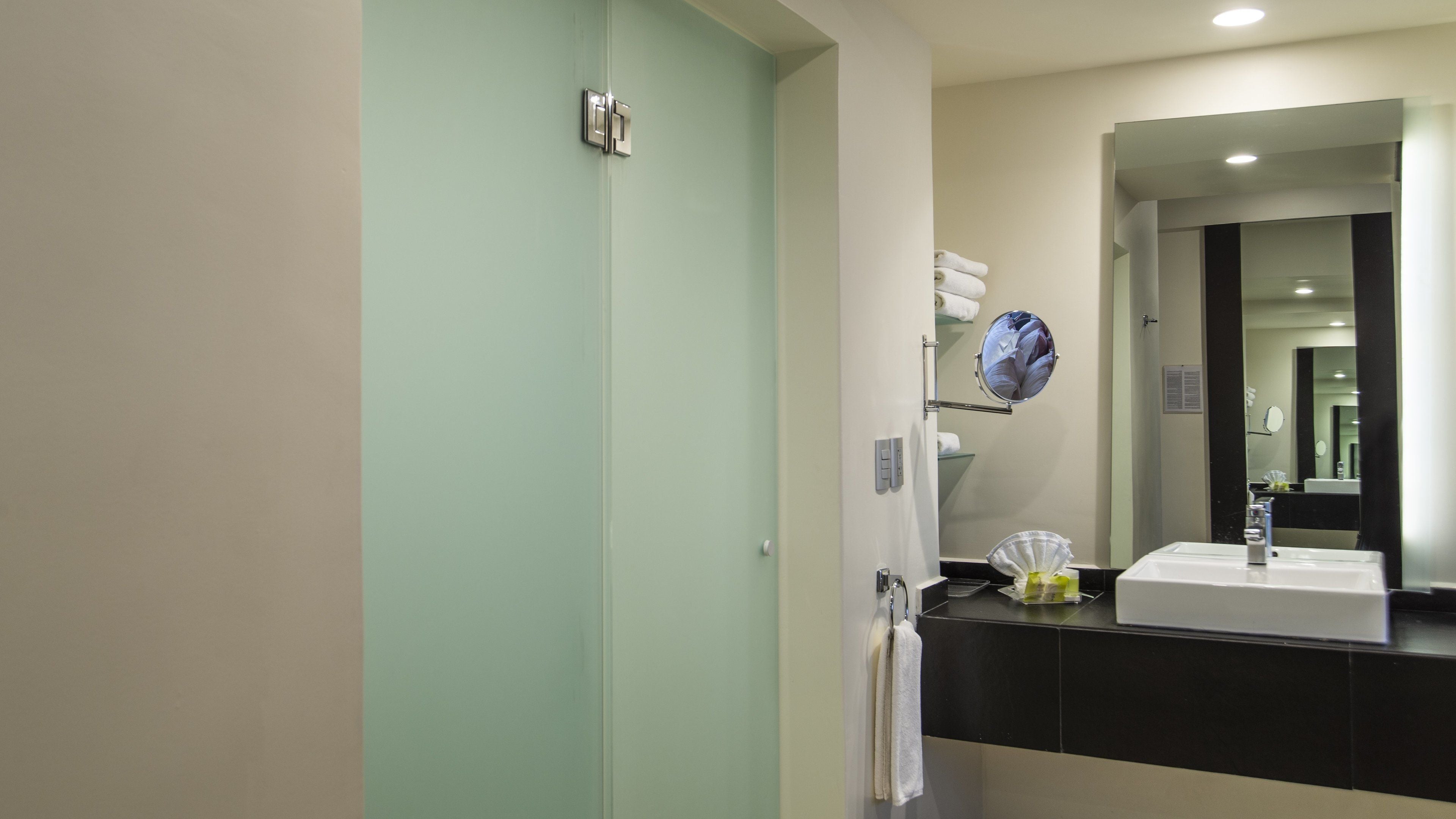A bathroom with a sink, mirror, and towel rack.