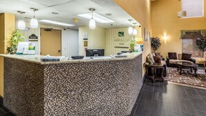 A hotel reception area with a mosaic-tiled counter, a Dell computer, and a sign reading "Quality Inn". - Quality Inn Rolla (Rolla)