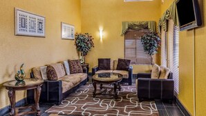 A living room with a sofa set, a coffee table, a side table, and a potted plant. - Quality Inn Rolla (Rolla)