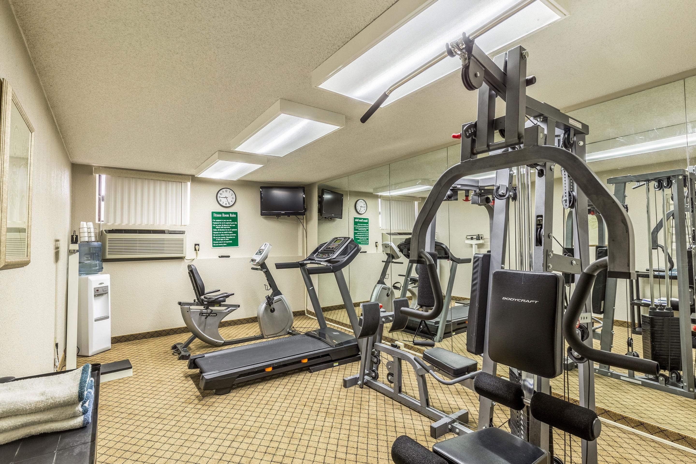 A gym with treadmills, weight machines, and a water dispenser.