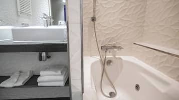 A modern bathroom with a white sink, a bathtub, and a towel rack.