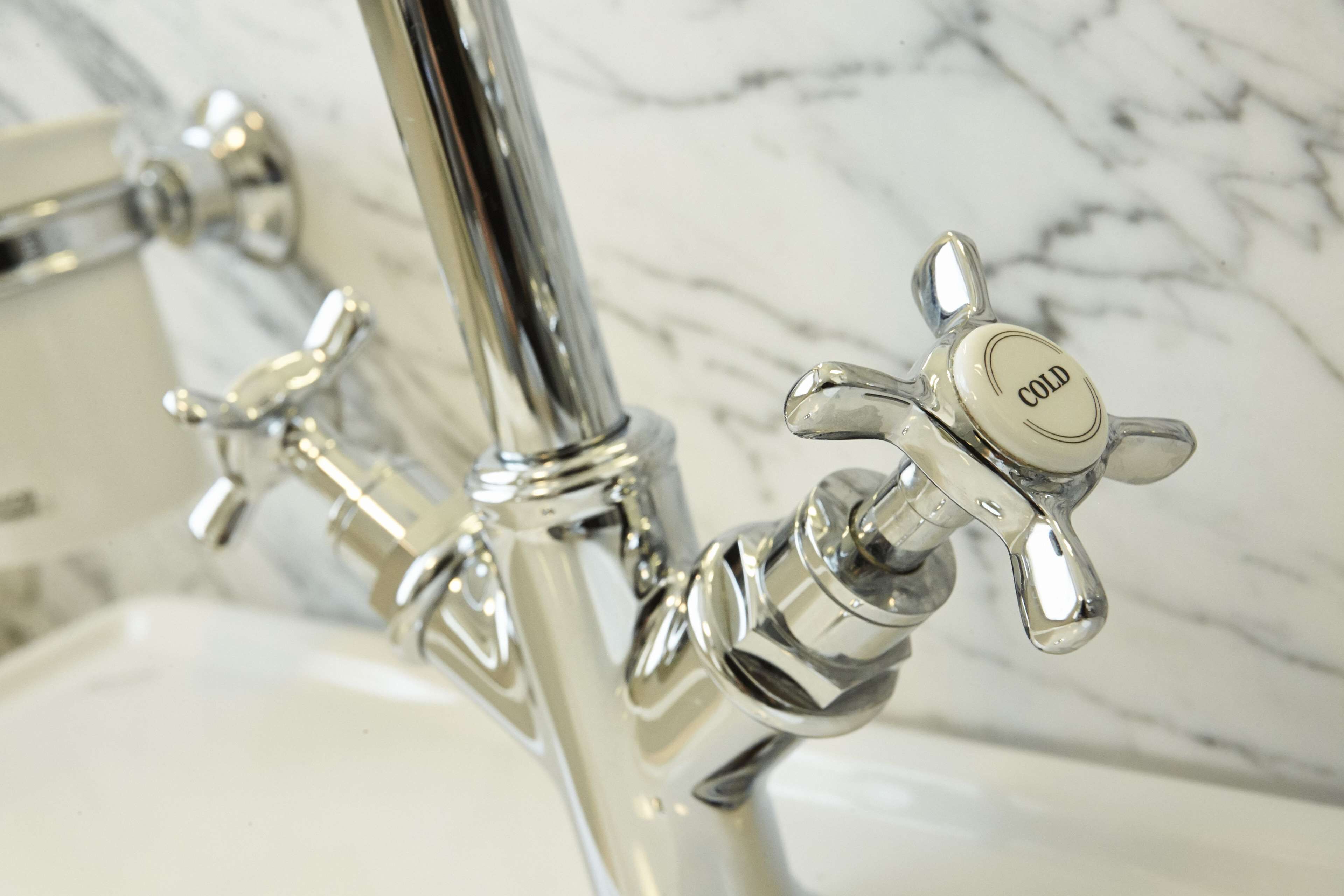 Un baño con grifo cromado y control de agua fría.