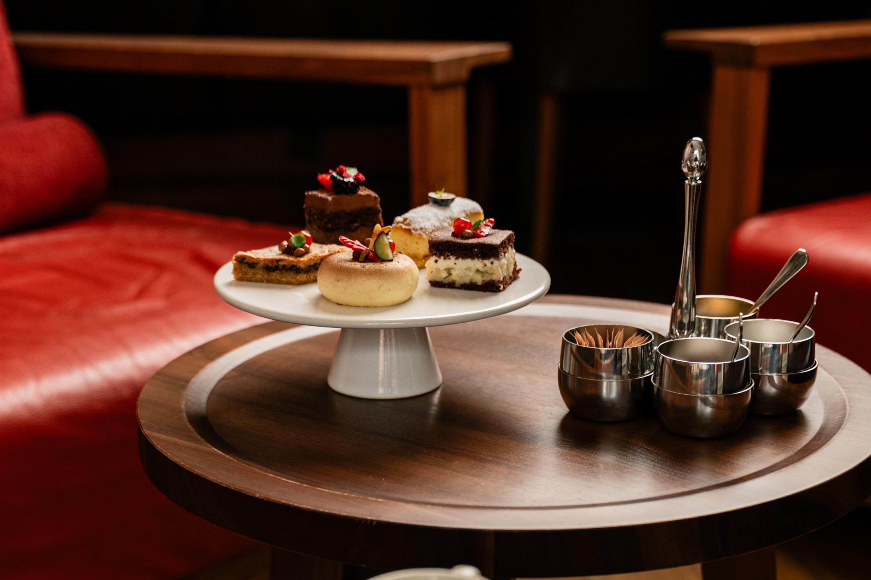 Eine Dessertplatte auf einem runden Tisch mit verschiedenen Backwaren und einem hohen Glas.