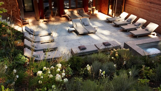 A rooftop lounge area with sun loungers and a hot tub.