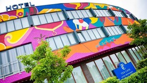 Un hôtel à la façade colorée, sur laquelle on peut lire l’inscription « TEN CATE HOTEL RESTAURANT ».