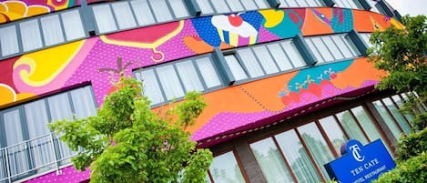 A hotel with a colorful exterior featuring a 'TEN CATE HOTEL RESTAURANT' sign.