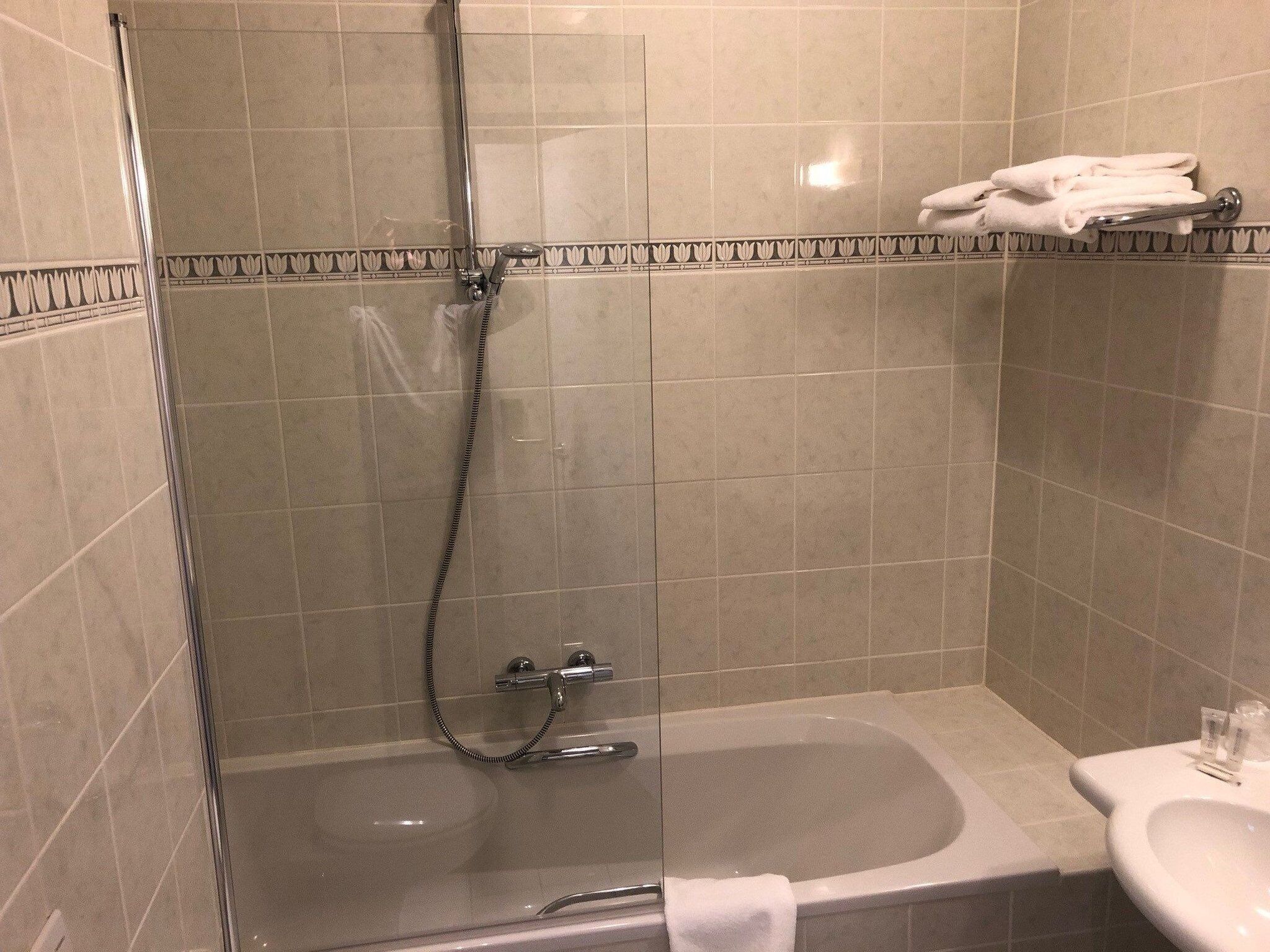 Un baño con ducha de vidrio, bañera y lavamanos.