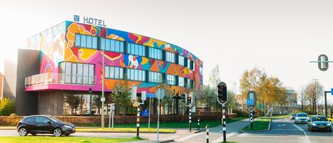 A modern hotel with a colorful exterior and a bike lane.