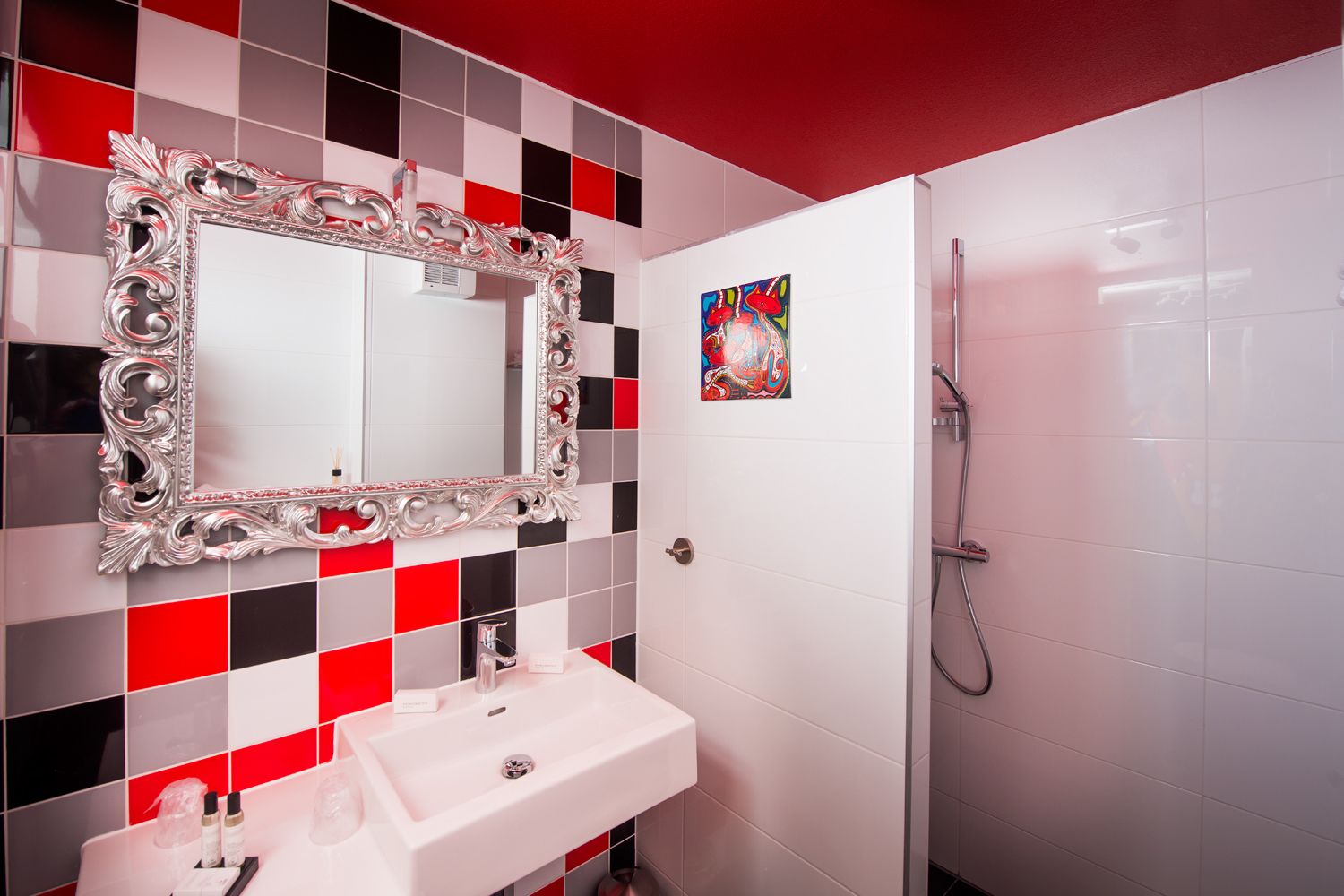 A bathroom with a white sink, a large ornate mirror, and a shower.