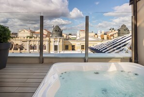 A hot tub on a wooden deck with a view of historic buildings and a clear sky. - Catalonia Gran Via Madrid (Madrid)
