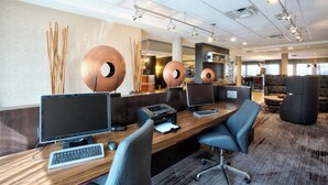 Et moderne kontormiljø med flere arbejdsstationer, et receptionsområde og et loungeområde.