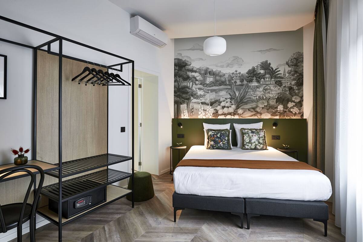 Un dormitorio moderno con una cama, un armario empotrado, un escritorio con silla y un mural en la pared.