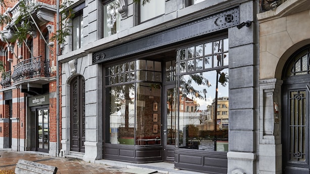 A building with large windows, a bench, and a door labeled "urban yard". - Urban Yard (Brussels)