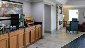 A modern kitchen with wooden cabinets, a coffee machine, and a stone accent wall. - Quality Inn Crossville Near Cumberland Mountain State Park (Crossville)