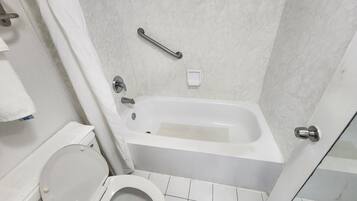 Un baño con una bañera blanca, un inodoro y una cortina de ducha.