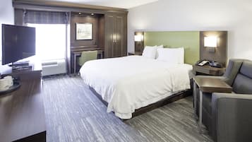 Une chambre d’hôtel avec un grand lit, un bureau avec un ordinateur, une chaise et un téléviseur.