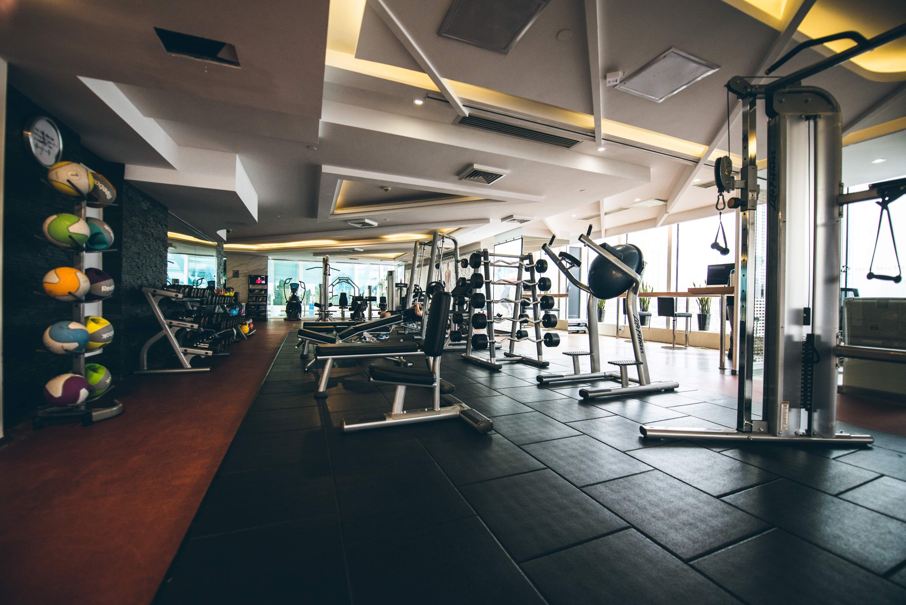 A gym with various exercise equipment, including treadmills, weight machines, and free weights.