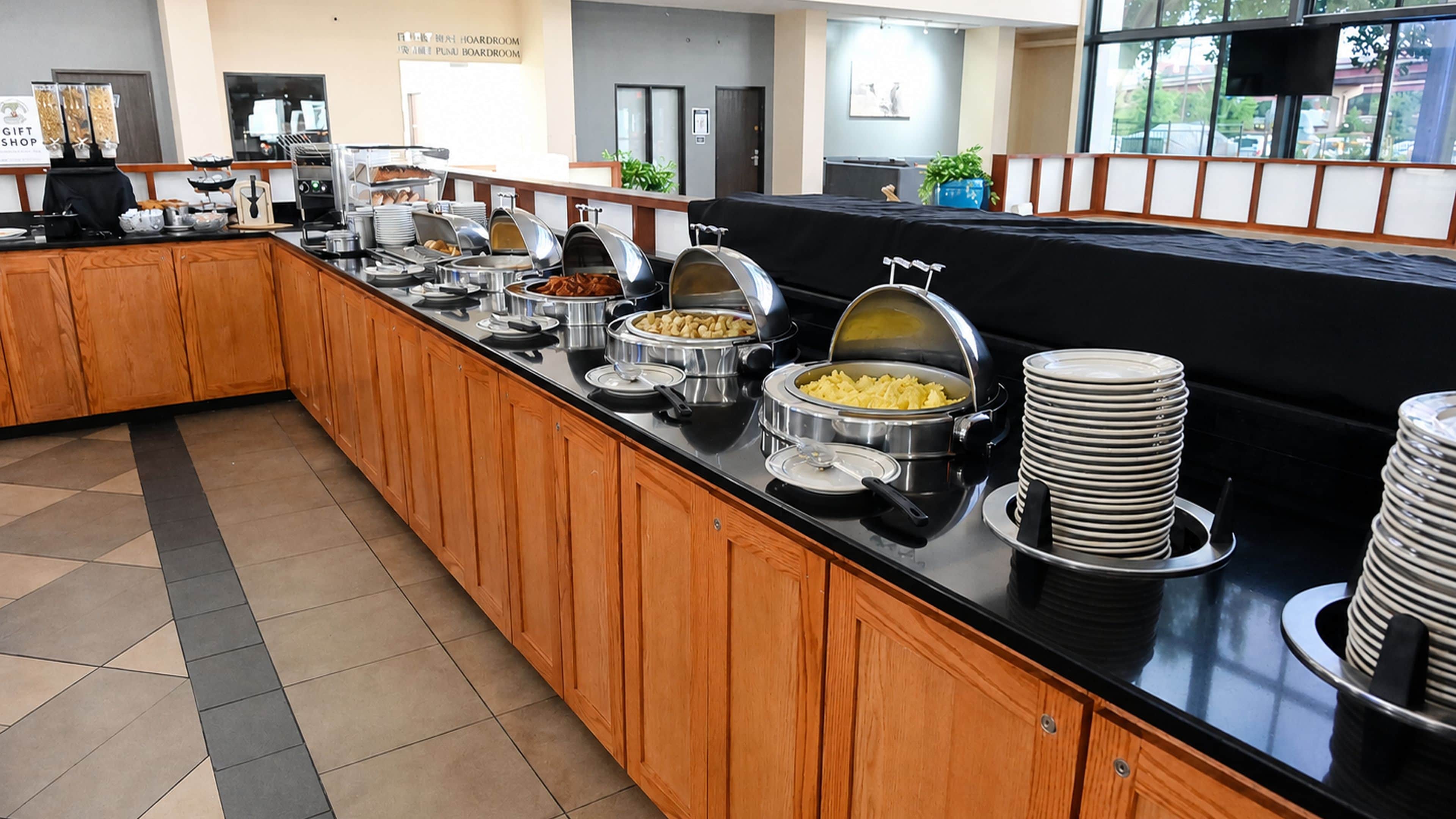 A buffet setup with various food items and a coffee station.