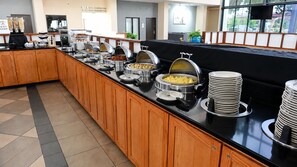 A buffet setup with various food items and a coffee station. - Atrium Hotel and Suites DFW Airport South (Irving)