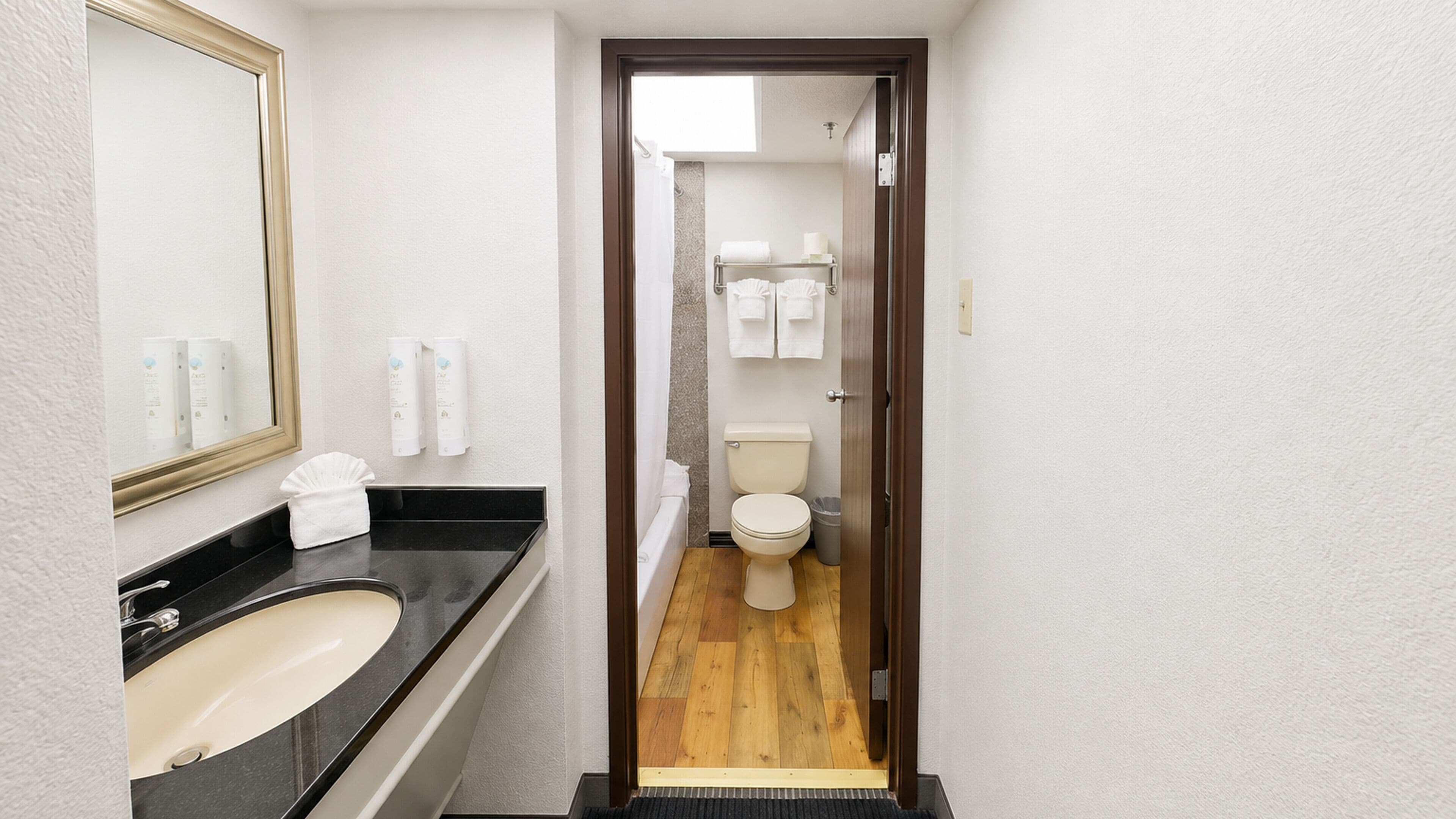 Une salle de bain d’hôtel avec un lavabo, un miroir et des toilettes.