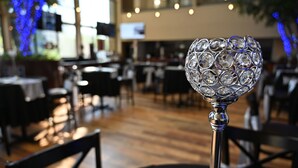 Ein Restaurant-Inneres mit Tischen, Stühlen und einem dekorativen Glasobjekt auf einem Tisch.