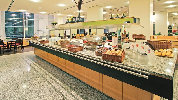 A buffet area with various food items and baskets. - ibis Dresden Zentrum (Dresden)