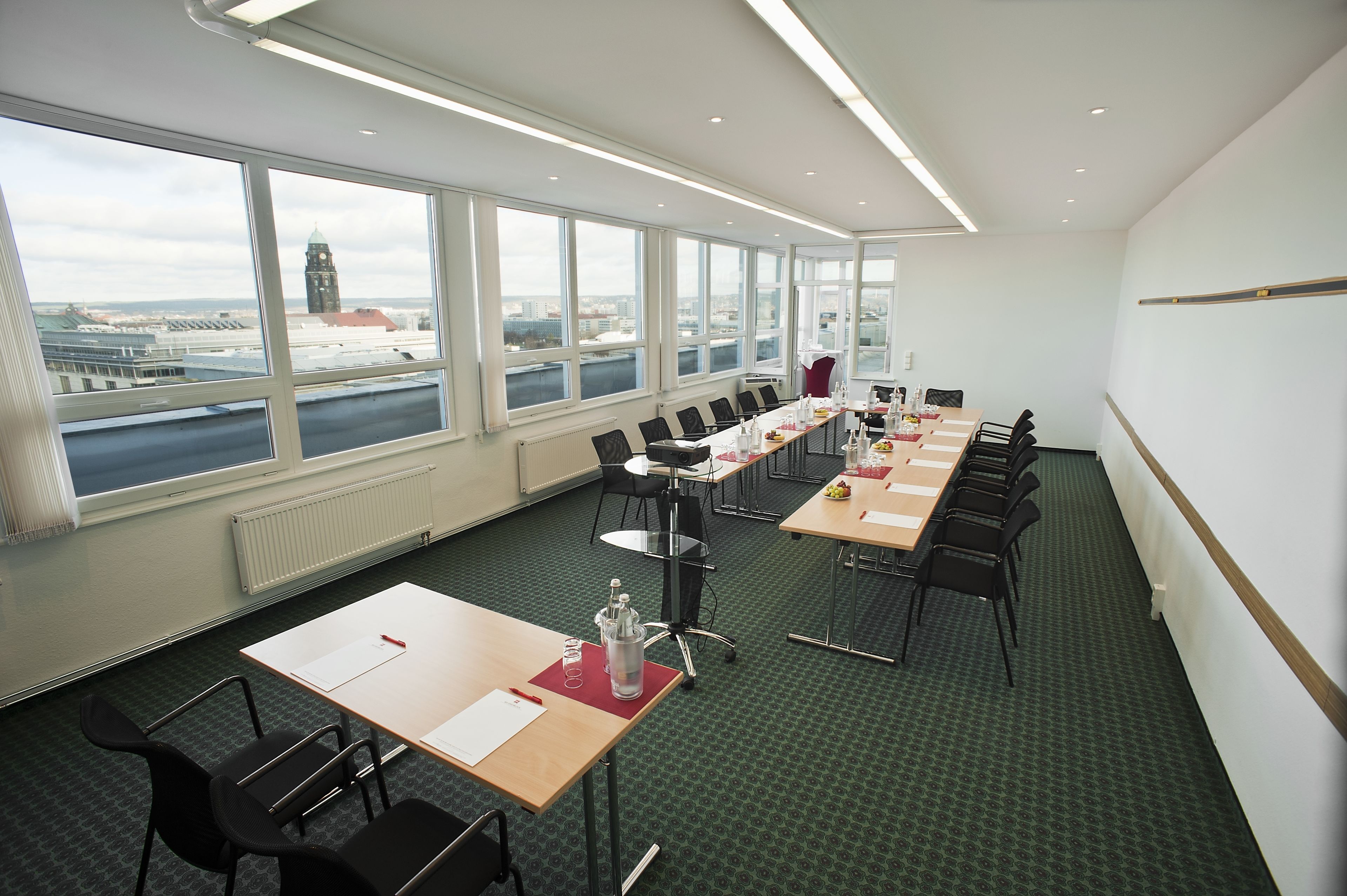 A conference room with large windows, a long table, and chairs.