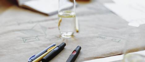 Un escritorio con un vaso de agua, un bolígrafo y una libreta.