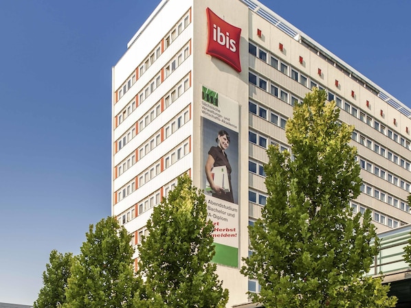 Useita kerroksia käsittävä rakennus, jonka julkisivussa on suuri, helposti havaittava »ibis»-kyltti, joka kertoo sen olevan hotelli.