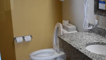 A bathroom with a toilet, sink, towel rack, and a mirror.
