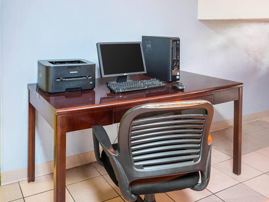A wooden desk with a desktop computer, a monitor, and a printer.