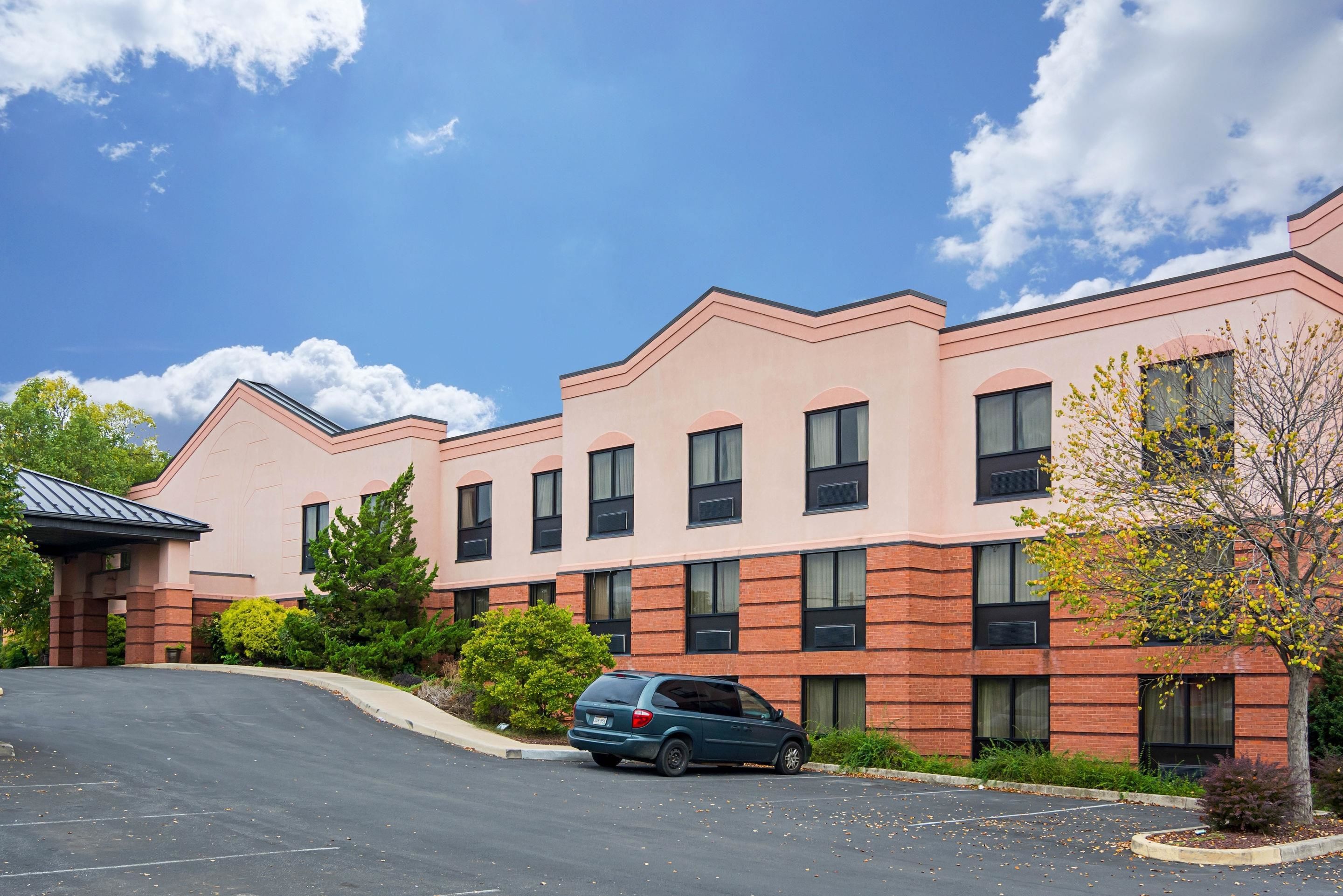 A multi-story building with a brick facade and a parking lot.