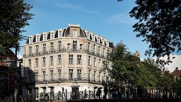 Un hotel histórico con fachada en esquina, varios balcones y una entrada destacada.