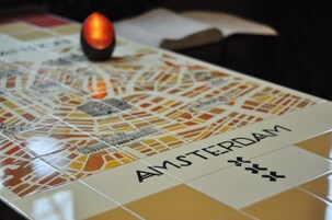 Primer plano de un suelo de baldosas con la palabra 'AMSTERDAM' y un diseño de mapa.