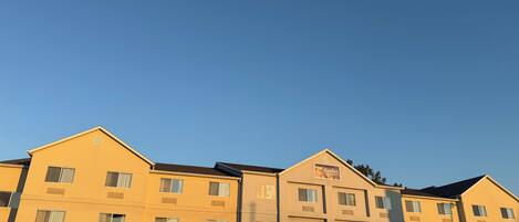 A multi-story hotel with a flat roof and a central entrance.
