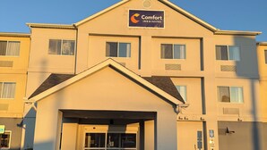 Un hôtel à plusieurs étages, reconnaissable à son enseigne bien visible indiquant « Comfort Inn & Suites ».
