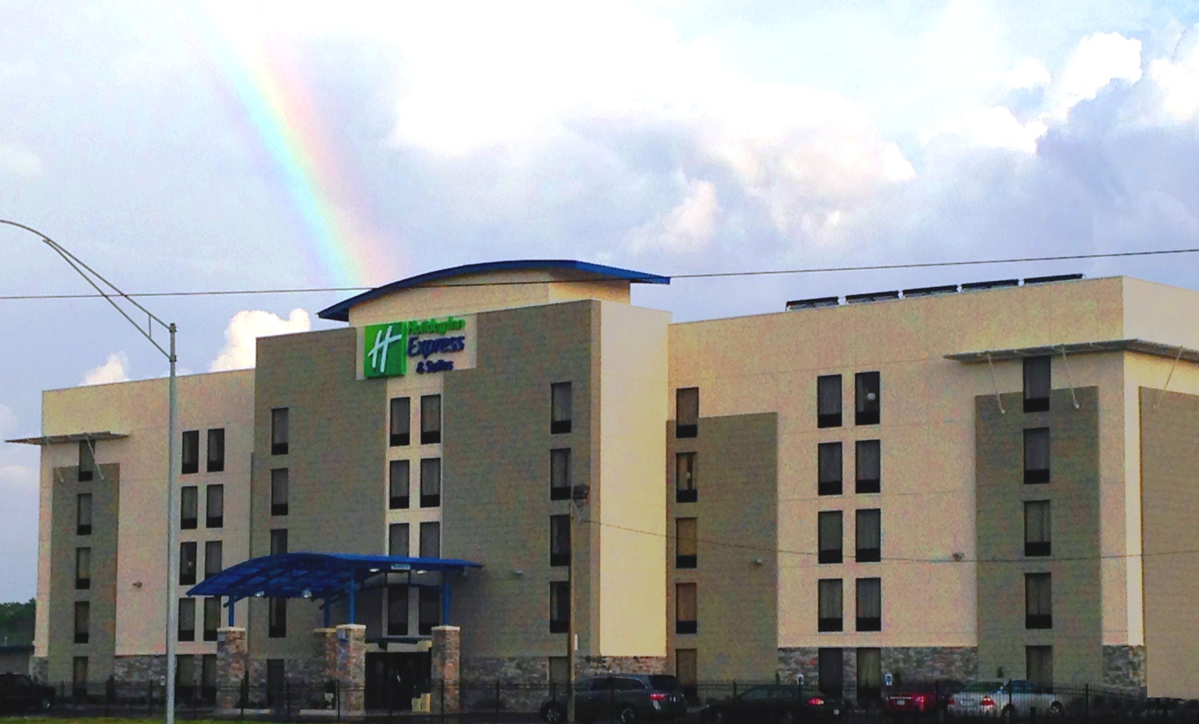 Un edificio de varios pisos con un letrero verde y blanco que indica que es un Holiday Inn Express & Suites.