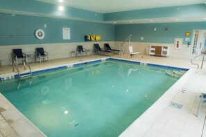 An indoor swimming pool with a tiled edge, multiple lounge chairs, and a lifeguard chair. - Holiday Inn Express & Suites Dayton Southwest by IHG (Dayton)