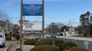 A Tourist Inn sign with amenities like free local calls, internet, HBO, continental breakfast, and special rates for studio rooms. - Tourist Inn (Absecon)