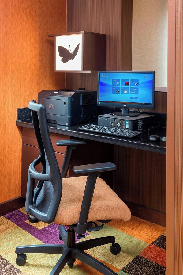 A modern office setup with a desktop computer, printer, and ergonomic office chair.