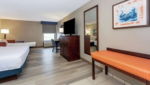A hotel room with two beds, a desk, a television, and a large mirror. - Hampton Inn Orlando-International Airport (Orlando)